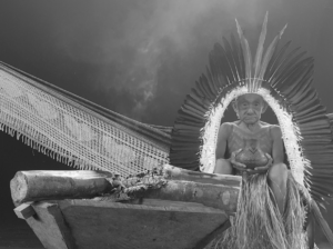 Yawanawá elder Tatá sits in an indigenous lodging.